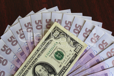 dollar and grivnas banknotes on dark background