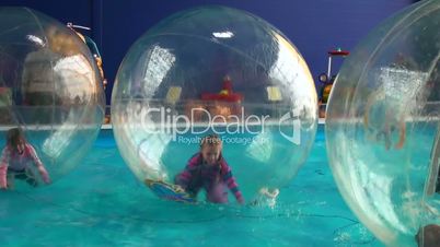 children in spheres on water