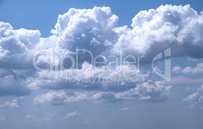 a horizontal shot of bright blue sky with puffy white clouds.