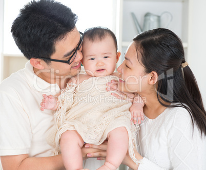 Parents kissing baby