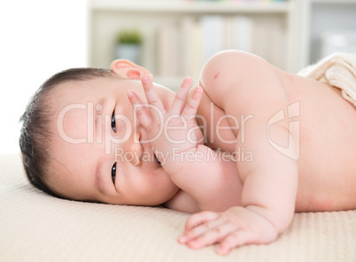Asian baby girl biting fingers