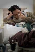 Sick woman with flu sneezing in bed