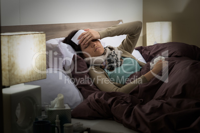 Young woman lying sick in bed cold