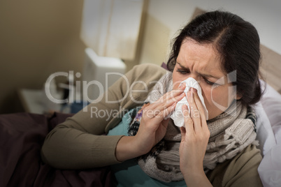 Woman having bad cold blowing her nose