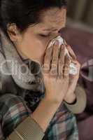Portrait of woman sneezing into tissue