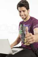 young male working on laptop thumbs up