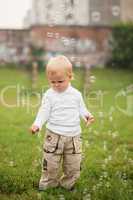 little  boy catches soap bubbles