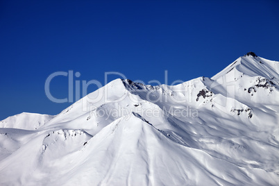 snowy winter mountains and clear blue sky in sun day