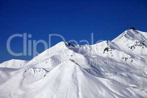 snowy winter mountains and clear blue sky in sun day