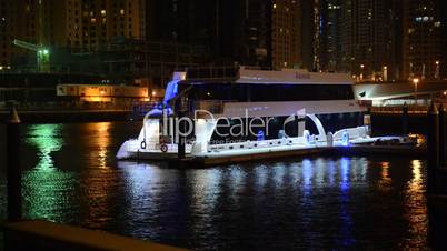 The night illumination of Dubai Marina and luxury yacht, UAE