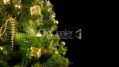 Green Christmas tree with gold ornaments rotate