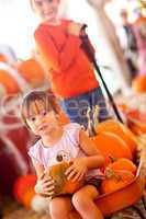 Cute Girl Riding Wagon with Her Pumpkin and Sister