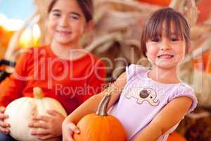 Cute Little Girls Holding Their Pumpkins At A Pumpkin Patch