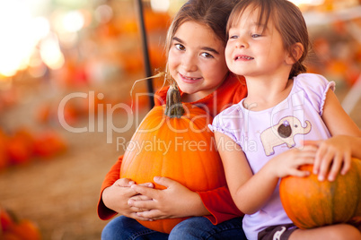 Cute Little Girls Holding Their Pumpkins At A Pumpkin Patch