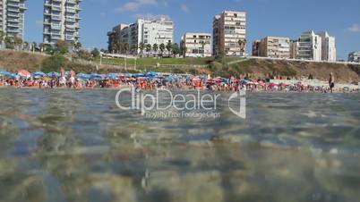 Crowded beach view from water.