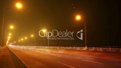 Timelapse of traffic on bridge at night. Blurred motion