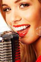 beautiful woman singing into a microphone