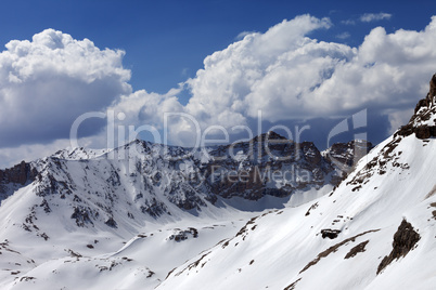 Snowy mountains and blue sky with cloud in sunny spring day