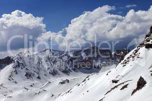 Snowy mountains and blue sky with cloud in sunny spring day