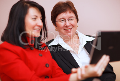 two women sharing a tablet computer
