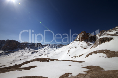 Snowy plateau and blue sky with sun