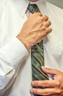 man fixing a tie with hands