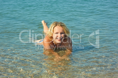 Teenage girl lying in coastal seawater