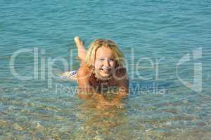 Teenage girl lying in coastal seawater