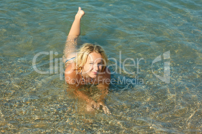 Teenage girl lying in sea water