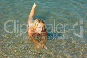 Teenage girl lying in sea water