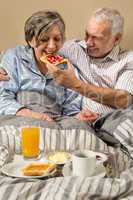 Senior man feeding breakfast to woman