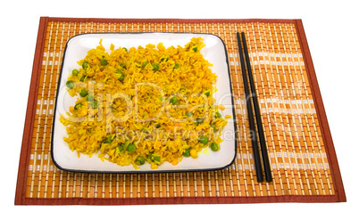 Rice with vegetables and chopsticks on bamboo mat