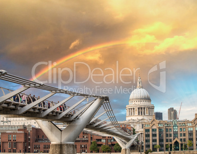 Rainbow over Millennium Bridge in London. St Paul Cathedral on b
