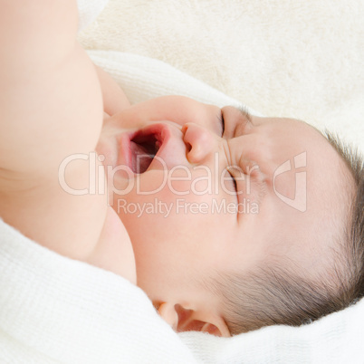 Asian baby boy crying on bed