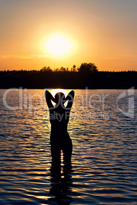 girl standing in the lake at sunset