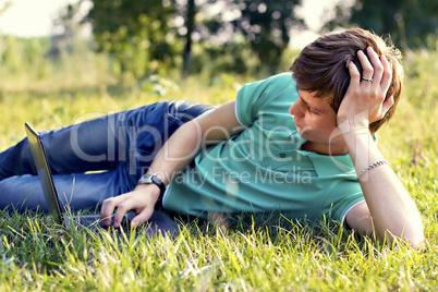 guy looks in the laptop outdoors