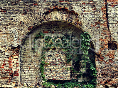 crumbling stone wall of an old house with brick masonry