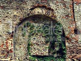 crumbling stone wall of an old house with brick masonry