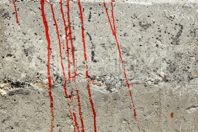 streaks of red paint on a concrete wall