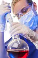 Female Scientist Pipette & Flask In Laboratory