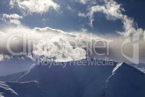 mountains in evening and sunlit clouds