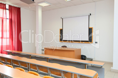 empty classroom with chairs, desks and chalkboard