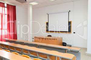 empty classroom with chairs, desks and chalkboard