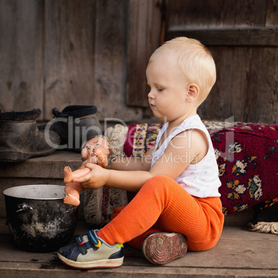 the little boy plays with a doll