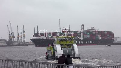 Hafenfähre und Containerschiff