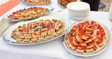 Trays with pieces of tomato pizza, omelets and rustic