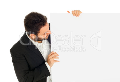 Portrait of a handsome young man looks at a white sign