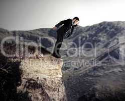 Young businessman falls from the cliff