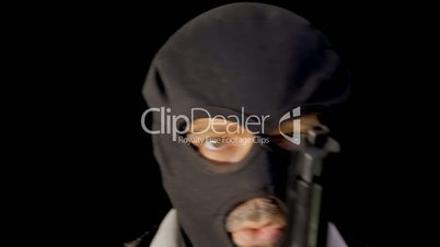 Masked criminal showing gun close up