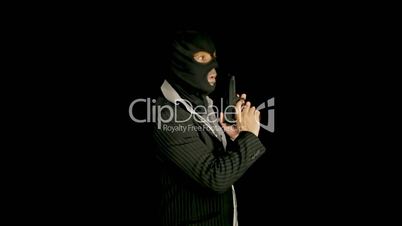 Masked criminal with gun looking around